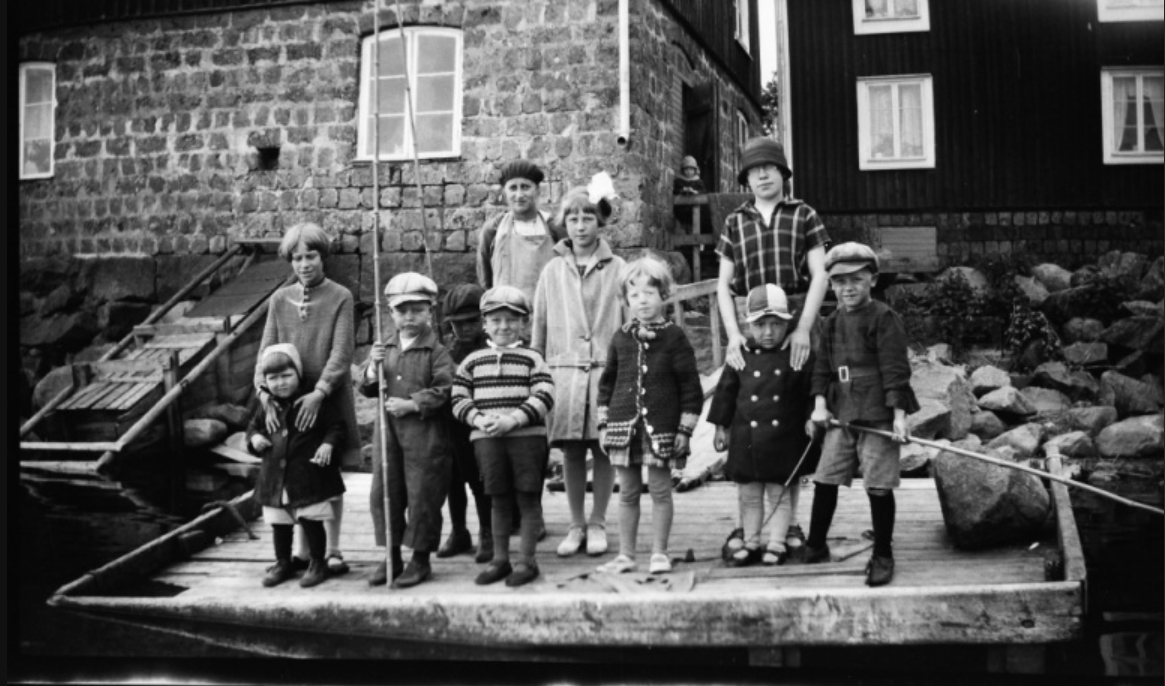Barn på flotte vid sjöbod